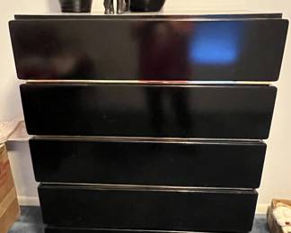 Postmodern black lacquer five-drawer chest featuring brass accents and brass plinth base