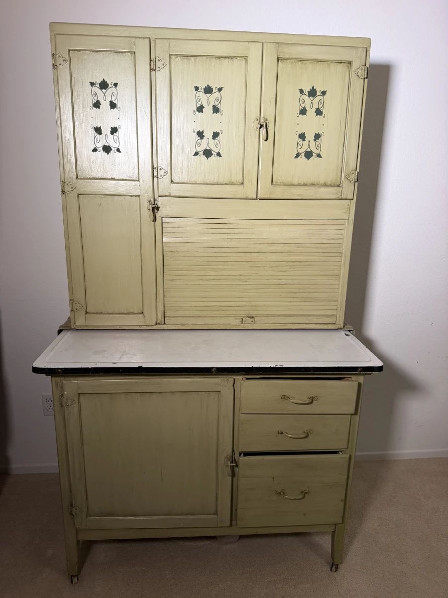 Antique Hoosier style kitchen cabinet with hand stenciled doors, tambour roll and enamel work top. Grandma's kitchen command center and the star of the show.