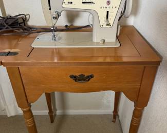 Vintage Singer sewing machine in its own wood cabinet. Crafters, this one has your name on it.