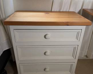 White nightstand with a knotty pine top. Cozy cottage vibes.
