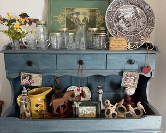 Blue painted hutch with Mason jars, a scenic plate, vintage tins and folk art goodies. Country kitchen magic.