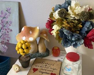 Mushroom figurines, faux blooms and a sign that says sisters are like fat thighs, they stick together. We laughed too.