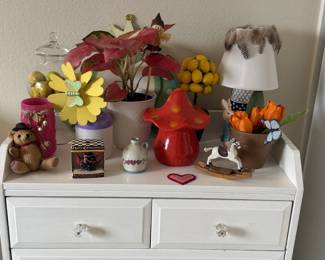 Red mushroom decor, a little lamp, faux florals and whimsical knickknacks. Cottagecore dreams come true.