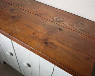 Stained wood top on the farmhouse cabinet. Great spot for a lamp and a stack of books.