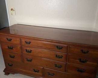 Long wood dresser with brass bail pulls. Storage for days.