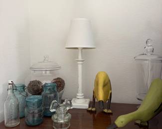 Blue Mason jars, glass apothecary jars, a white lamp and a pair of quirky birds.