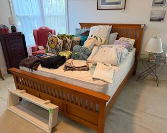 Queen mission style wood bed frame with mattress and box, linens, jewelry dresser, wing-backed chair, Restoration Hardware wall shelf, decorative pillows