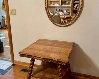 Vintage wooden accent table with barley-twist legs, scalloped edges, lower shelf, and ornate brass-tone claw-and-ball casters • Elegant oval wall mirror