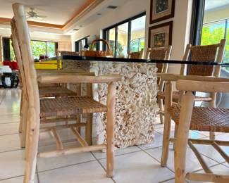custom dining table features inch-thick glass and two coral pedestals. The chairs are slightly rustic (but with a smooth finish) and eye-catchers all on their own. The sale features barstools and a bench that match the chairs.
