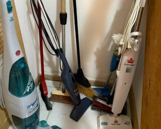 assorted brooms, mops, etc.