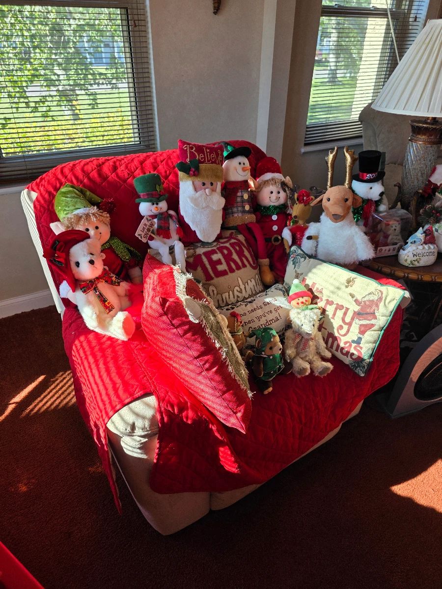 Christmas plush Santas, snowmen and elves on red-covered recliner