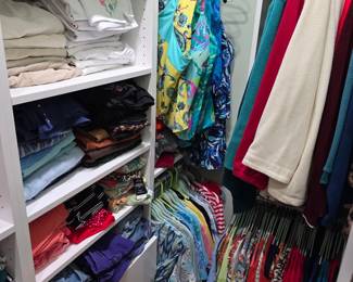 Women's folded sweaters and hanging tops in closet