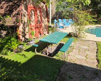 Backyard with green picnic table and red shed