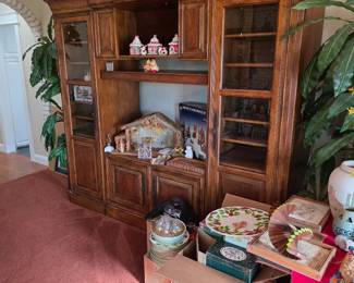 Dark wood lighted china hutch with Christmas village pieces and dishes