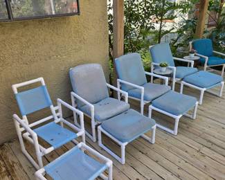Deck with white PVC patio chairs, ottomans and blue cushions