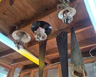 Antique-style hand saws and light fixtures hung from rafters