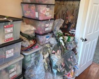 Clear bins of holiday decor with hanging garments