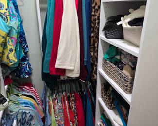 Walk-in closet with women's tops, jackets and baskets