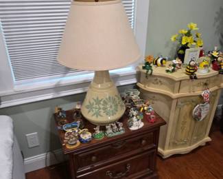 Ceramic floral table lamp on wood nightstand with figurines