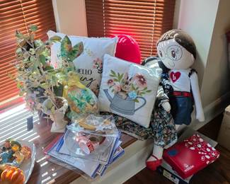 Window seat with floral pillows, plush doll and fall decor