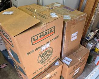 Stacked U-Haul boxes of jigsaw puzzles in garage