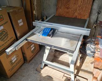 Table saw on stand with extension wings in garage