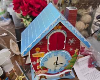Christmas village clock house with poinsettias and decor