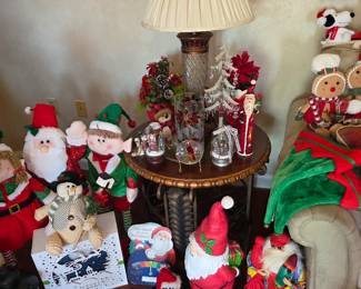 Christmas plush Santas, snowmen and gnomes around wicker side table