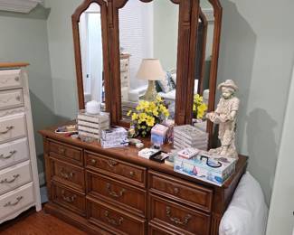 Wood dresser with triple arched mirror, figurines and floral decor