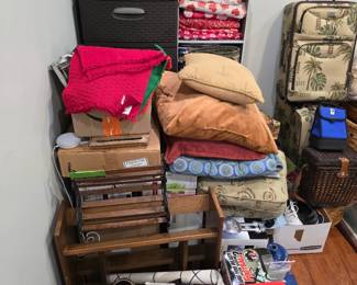 Room corner with luggage, pillows, fabric and storage bins