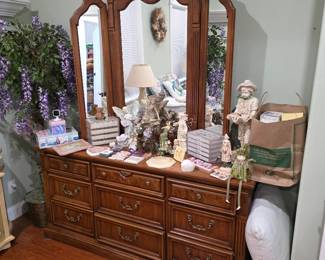 Wood dresser with triple arched mirror, figurines and faux wisteria
