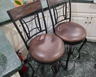 Pair of metal swivel bar stools with brown seats