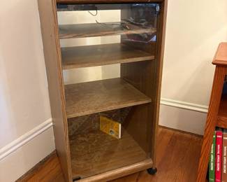  R37 - $30. Rolling media cabinet. Measures 19" x 17.5" x 38.5" tall. Shelves are adjustable and glass door push pushes open. 