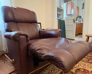 R31 - $100. Brown leather La-Z-Boy rocking recliner. Very good condition. No holes or rips noted. Measures 33" x 36" x 39" tall. 