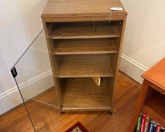  R37 - $30. Rolling media cabinet. Measures 19" x 17.5" x 38.5" tall. Shelves are adjustable and glass door push pushes open. 