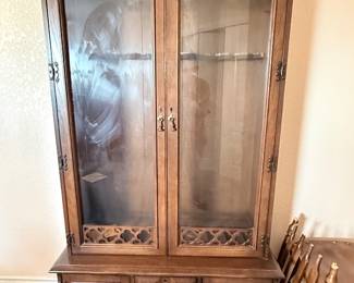 Vintage wooden china cabinet with glass-front display doors, decorative fretwork, and lower storage drawers and cabinets.