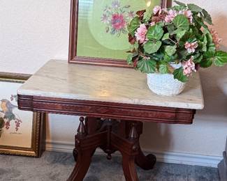 Vintage marble-top accent table with ornate carved wooden pedestal base and curved legs.