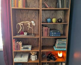 Oak bookshelves, pair, 6 shelves each. Ceramic bird figurine. Ceramic apples, set of 3 (blue, green, black). Silver metal hurricane lantern.