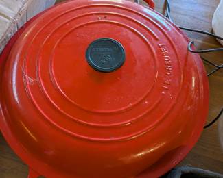 Le Creuset cherry red enameled cast iron braiser with lid. Large round covered casserole.