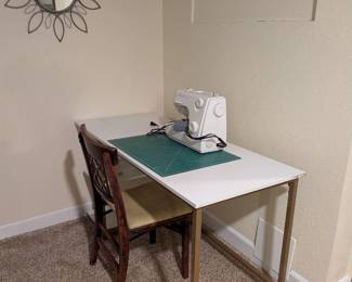 White and gold desk, modern metal frame. Vintage wood chair with yellow leather seat. Metal flower starburst mirror.