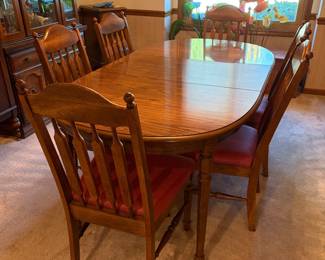Traditional solid oak dining set with extendable oval dining table (with a leaf installed) and matching high-back spindle/arrow back chairs with upholstered seats