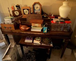 Piano with clocks & collectibles. Wooden duck carving.