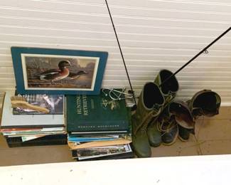 709 - Group Lot of Assorted Items (Description): A group lot of assorted items including various books, a framed duck print, fishing rod, and boots. Items sold as one lot.