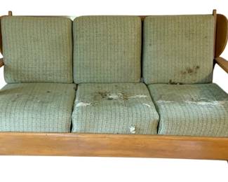 1045 - Sofa w/ Stains 34"x62"x28" (Description): A sofa with visible staining on the cushions. The piece features a wooden frame with curved armrests and three back cushions with three seat cushions. Measures 34 inches high by 62 inches wide by 28 inches deep.