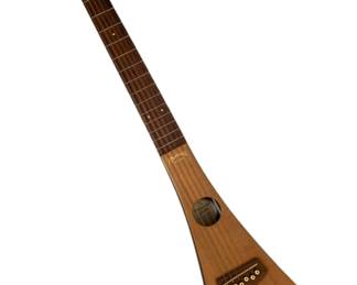 340 - Martin Backpacker Steel String Travel Guitar (Description): The Backpackers Guitar, a compact travel-friendly acoustic guitar designed for portability. Measures 35 inches in length by 8 inches in width.