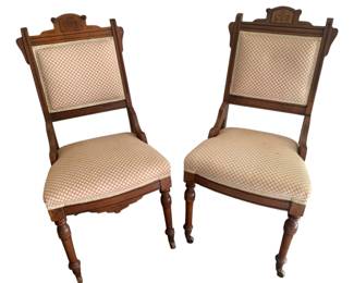 347 - Pr Victorian Chairs w/ Upholstery (Description): A pair of Victorian chairs featuring upholstery on both the seat and back panels. The wooden frames showcase carved details and the chairs rest on turned front legs with casters. Measurements: 37" x 19" x 16".