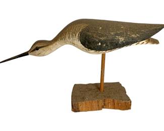 1050 - Carved Wood Shore Bird 8"x14" (Description): A carved wood bird decoy featuring a long-billed shorebird mounted on a wooden dowel and rustic wood base. The piece displays hand-painted details with natural weathered patina. Measures 8 inches by 14 inches.