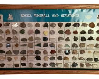 770 - Rocks, Minerals & Gemstones Framed 12"x26" (Description): A framed educational display featuring a collection of rocks, minerals, and gemstones. Each specimen is individually labeled and mounted against a teal background within an oak frame. The display measures 12 inches by 26 inches.