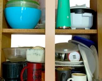 1038 - Cabinet Lot of Assorted Kitchen Items (Description): A cabinet lot of assorted items including various kitchen pieces such as bowls, containers, mugs, and other household items.