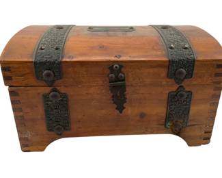 675 - McGraw Box Co. Wooden Box 5"x9"x6" (Description): McGraw Box Co. wooden box featuring a domed lid with decorative metal strapping and hardware. The box has ornate metal corner plates and a front latch closure. Measures 5 inches by 9 inches by 6 inches.